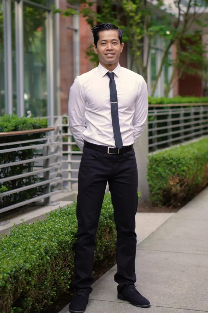 Kinesiologist and personal trainer Tee Live from Tee Live Fitness And Kinesiology standing outdoors in dress clothes.