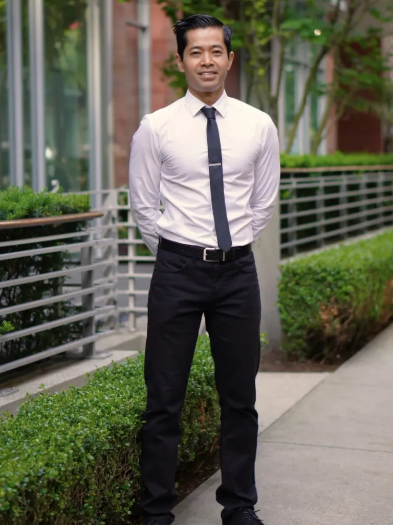 Kinesiologist and personal trainer Tee Live from Tee Live Fitness And Kinesiology standing outdoors in dress clothes.
