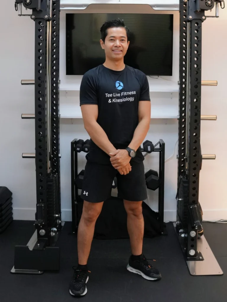 Kinesiologist and personal trainer Tee Live from Tee Live Fitness And Kinesiology in Langley standing in front of fitness equipment.