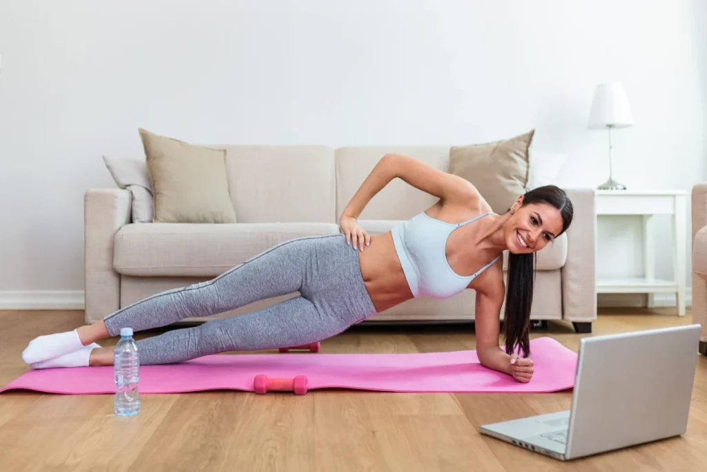 Fit woman doing an online fitness or injury recovery session at her home.