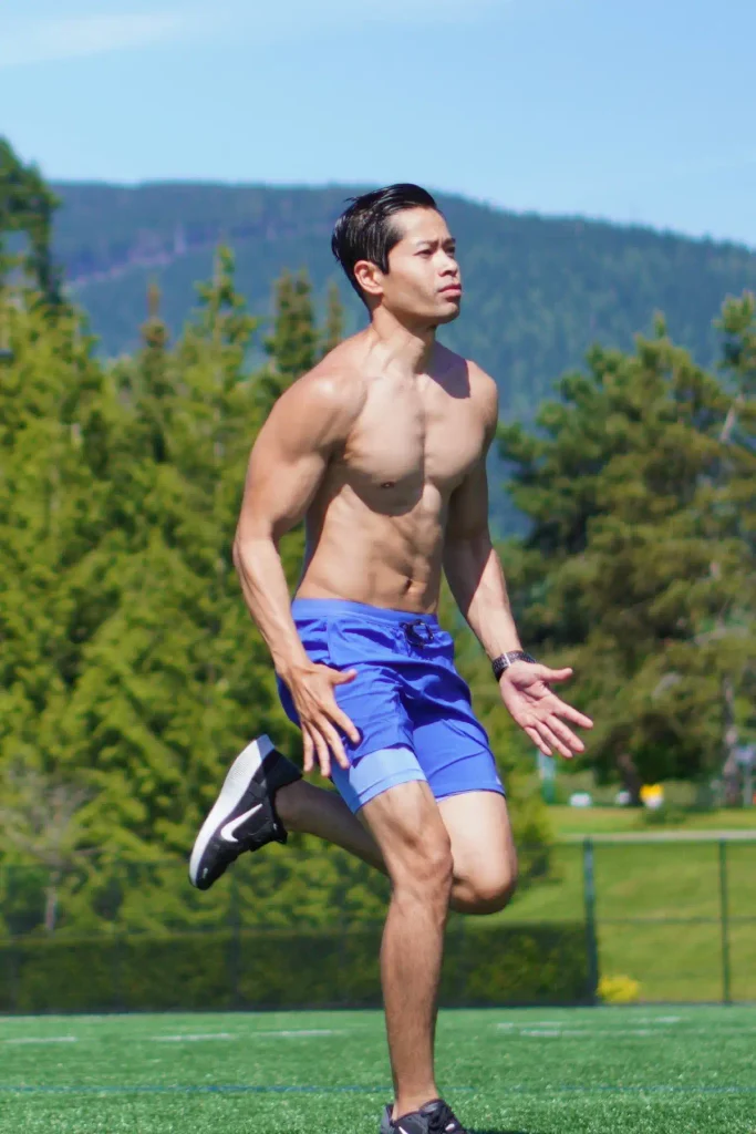 Personal trainer and kinesiologist Tee Live from Tee Live Fitness And Kinesiology wearing blue shorts running outdoors on a sunny day at the park.