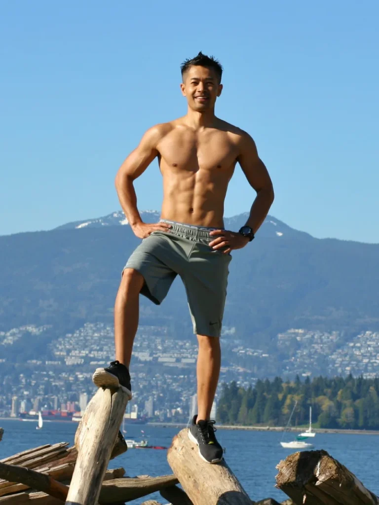 Personal trainer and kinesiologist Tee Live from Tee Live Fitness And Kinesiology standing at logs at the beach.
