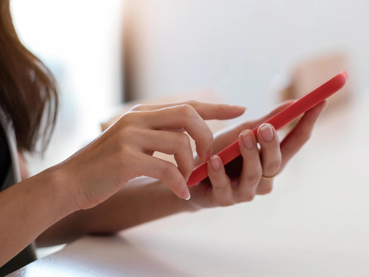 Woman is on the phone filling out intake forms for her fitness and injury recovery programs.